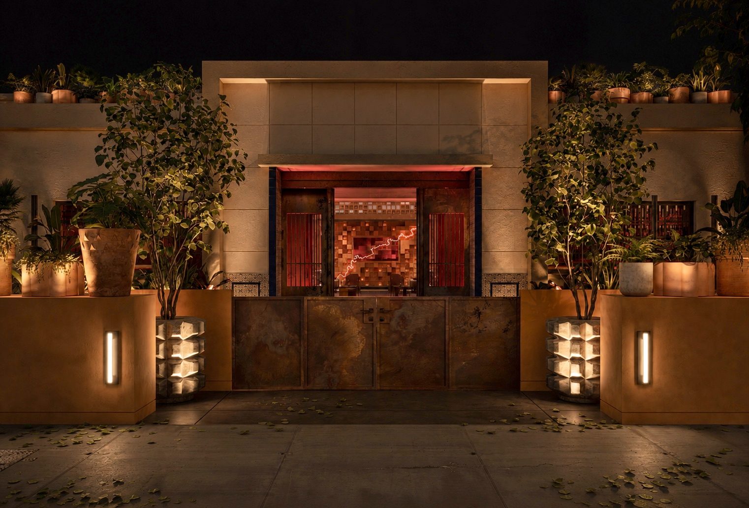 Pablo's front entrance at night, framed by lush planters and warm architectural light